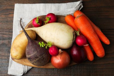 Tahta masada farklı çiğ sebzeler, üst manzara.