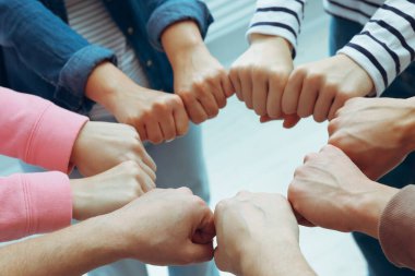 Kapalı mekanda el ele tutuşan insanlar, yakın çekim. Takım oluşturma