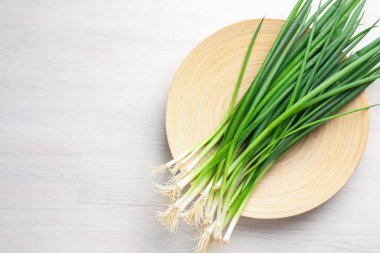 Beyaz ahşap masada taze taze taze soğanlar, üst manzara. Metin için boşluk