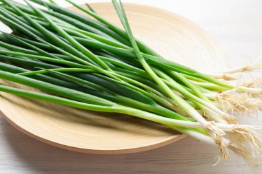 Taze taze taze soğanlar beyaz ahşap masada, yakın plan.