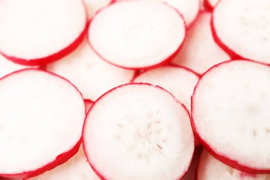 Arka plan olarak taze turp dilimleri, yakın plan.