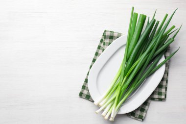 Beyaz ahşap masada taze taze taze soğanlar, üst manzara. Metin için boşluk