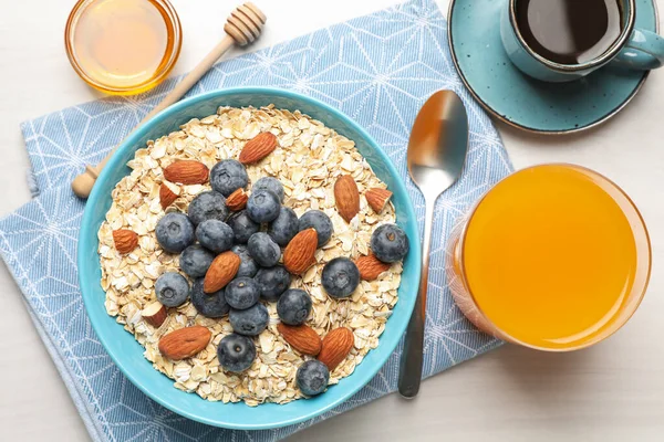 Kuru yulaf, fındık ve yaban mersini kahvaltıda gri ahşap masada servis edilir.