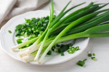 Taze taze taze soğanlar beyaz ahşap masada, yakın plan.