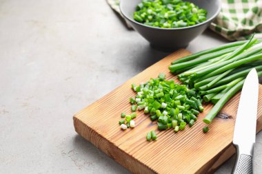 Açık gri masada yeşil soğan ve bıçak kes, yakın plan. Metin için boşluk