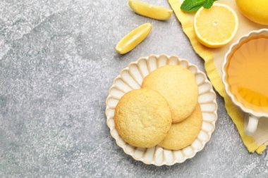 Lezzetli limonlu kurabiyeler ve gri masada meyve dilimleri. Metin için boşluk