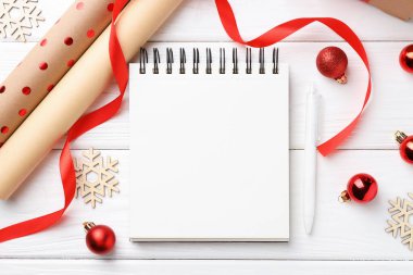 Yeni yıl hedefleri. Boş planlayıcı, kalem ve beyaz ahşap masa üzerinde şenlikli bir dekor.