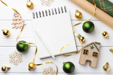 Yeni yıl hedefleri. Boş planlayıcı, kalem ve beyaz ahşap masa üzerinde şenlikli bir dekor.