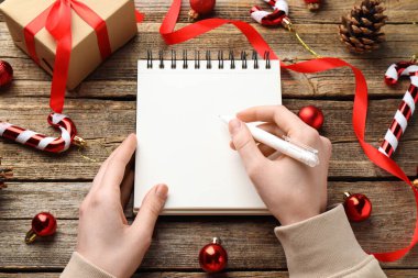 Yeni yıl kararı. Ahşap masada Noel dekoru olan planlamacı bir kadın. Metin için boşluk