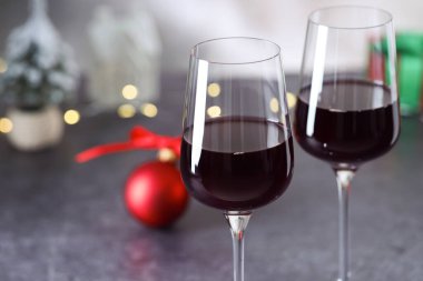 Gri masada kırmızı şarap ve Noel süsü, yakın plan. Metin için boşluk