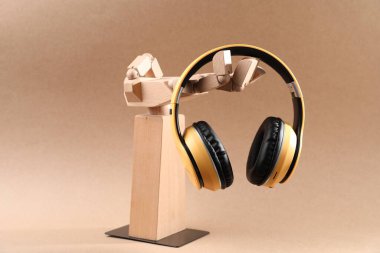 Bej arka planda şık kulaklıklı manken el.