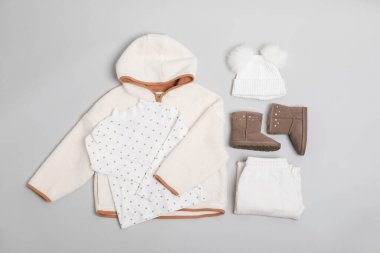 Şık çocuk kıyafetleri ve hafif arka planda ayakkabılar, düz yatış.