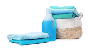 Çamaşır sepeti, havlular ve beyaza izole edilmiş bir şişe deterjan.