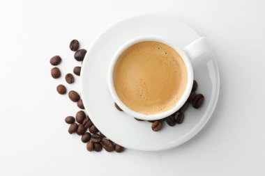 Beyaz arka planda bir fincan aromatik kahve ve kızarmış fasulye.