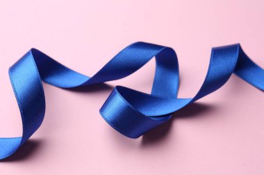 Pembe arka planda güzel mavi kurdele, yakın plan.