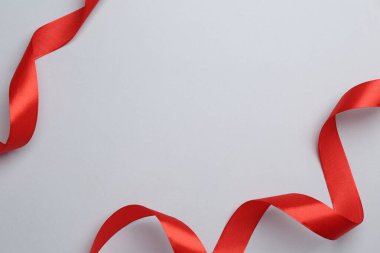 Açık arkaplanda güzel kırmızı kurdeleler, düz bir zemin. Metin için boşluk