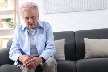 Evde diz ağrısı çeken yaşlı bir kadın, mesaj için yer var. Romatizma belirtileri