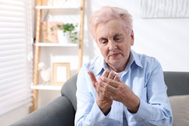 Evde avuç içi ağrısı çeken yaşlı bir kadın. Romatizma belirtileri