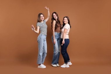 Kahverengi arka planda üç mutlu arkadaşın portresi