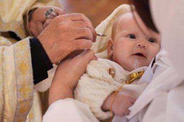 Kilisede vaftiz töreni düzenleyen rahip, yakın plan.