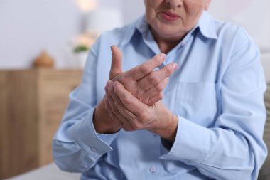 Evde avuç içi ağrısı çeken yaşlı bir kadın. Romatizma belirtileri