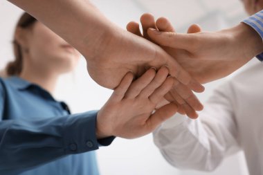 Ev içinde el ele tutuşan insanlar, düşük açı manzaralı. Takım oluşturma