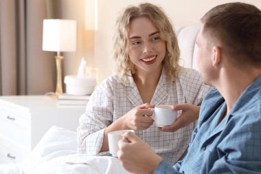 Hoş bir çift evde sıcak içeceklerin tadını çıkarıyor.