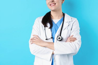 Açık mavi arka planda steteskoplu doktor, yakın plan. Metin için boşluk