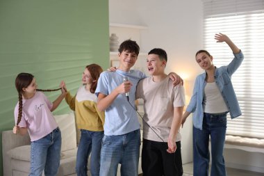 Genç arkadaşlar evde birlikte karaoke yapıyorlar.