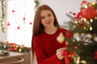 Evde Noel ağacı süsleyen güzel bir genç kız. Metin için boşluk