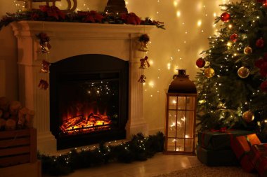 Güzel bir şömine, Noel ağacı ve karanlık odada şenlikli bir dekor. İç tasarım