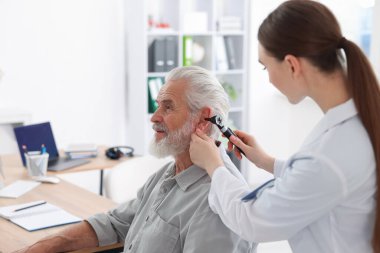 Duyma testi. Klinikte hastanın kulağını yıldız falıyla muayene eden doktor.