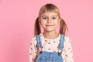 Pembe arka planda küçük şirin bir kızın portresi.