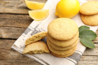 Lezzetli limonlu kurabiyeler ve ahşap masada meyve dilimleri, yakın plan.