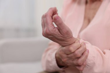 Romatizma belirtileri. Evde bilek ağrısı çeken son sınıf öğrencisi kadın, yakın plan. Metin için boşluk