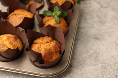 Gri masada kuru üzümlü ve nane şekerli lezzetli kekler, yakın plan. Metin için boşluk