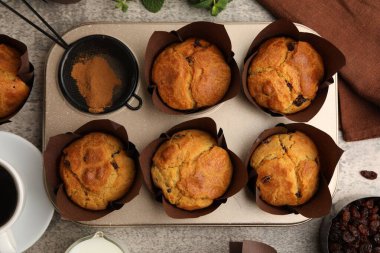 Üzümlü lezzetli kekler, nane şekeri ve kahve gri masanın üzerinde.