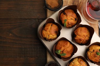 Kuru üzümlü lezzetli kekler, nane şekeri ve ahşap masa üzerinde çay, üst manzara. Metin için boşluk