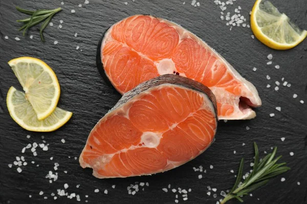 Baharatlı ve limonlu somon fileto parçaları siyah desenli masa, düz yatıyordu.