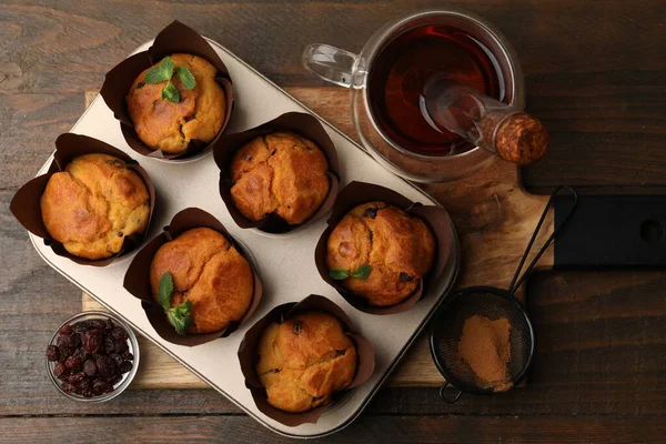 Kuru üzümlü lezzetli çörekler, nane şekeri ve ahşap masa üzerinde çay.