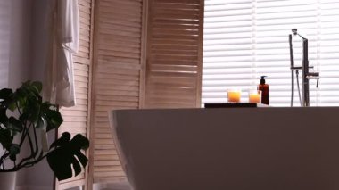 Katlanan ekran ve küveti olan şık bir banyo. Kamera ileri gidiyor