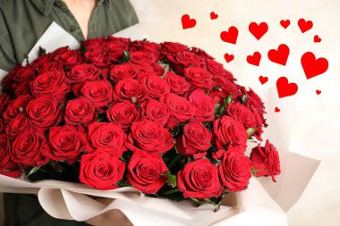 Elinde büyük bir buket kırmızı gül tutan kadın, yakın plan. Kalpli romantik tebrik kartı.