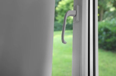 Kapalı pencere, yakın çekim. Yeşil bahçe, camdan manzara