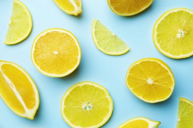 Açık mavi arka planda taze limonlar, düz uzanmış.