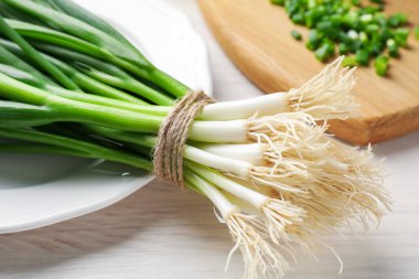 Taze taze taze soğanlar beyaz ahşap masada, yakın plan.