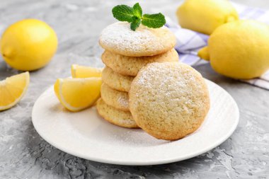 Lezzetli limonlu kurabiye ve meyve dilimleri gri masada, yakın plan.