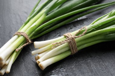 Siyah masada taze taze soğanlar, yakın plan.