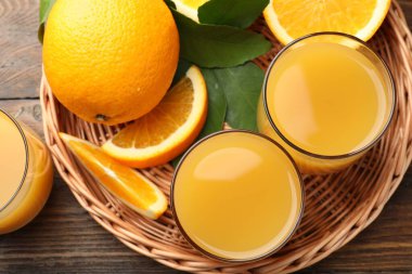 Taze portakal suyu, meyveler ve yeşil yapraklar ahşap masa, üst manzara