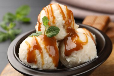 Karamel soslu lezzetli dondurma ve siyah masada nane şekeri.