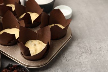 Kek yapıyorum. Gri masa üzerinde hamurlu kek tepsisi ve diğer farklı malzemeler, yakın plan. Metin için boşluk